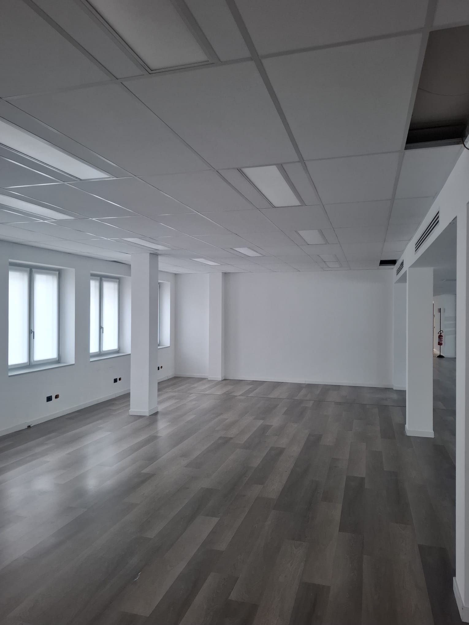 Open space finito con controsoffitto modulare e pavimento continuo